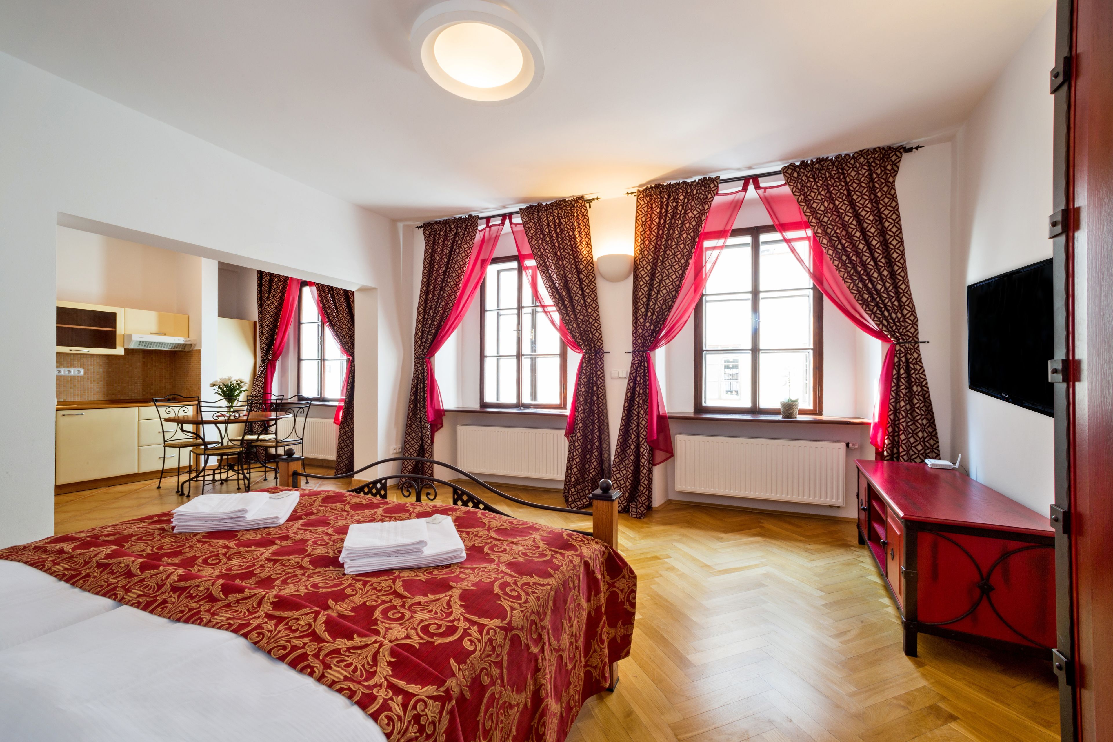 Habitación de hotel con una cama grande, un escritorio, una silla y un televisor.