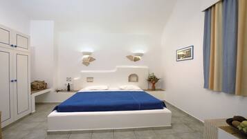 A bedroom with a bed, bedside tables, a wardrobe, and a wall-mounted light fixture.