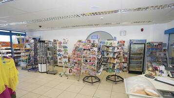A bookstore with multiple magazine racks and a refrigerated display case.
