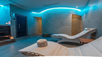 Experience relaxation in this serene spa room with a massage table, candlelit ambiance, and a clean, uncluttered space.