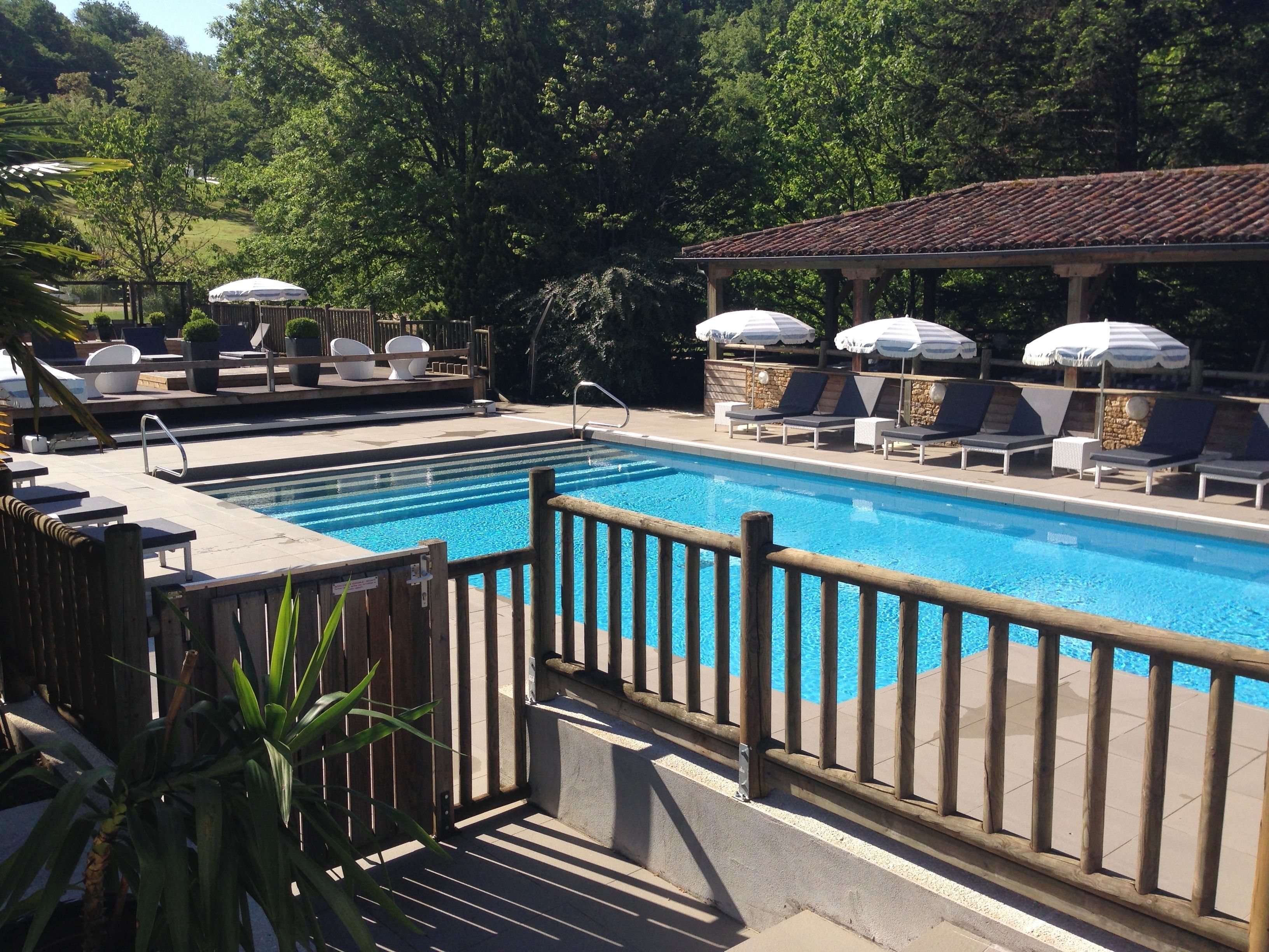 seasonal outdoor pool, a waterfall pool, pool umbrellas, pool loungers