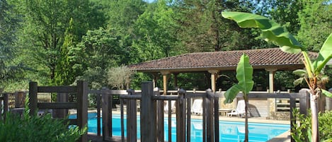 Una piscina al aire libre de temporada, una piscina con cascada