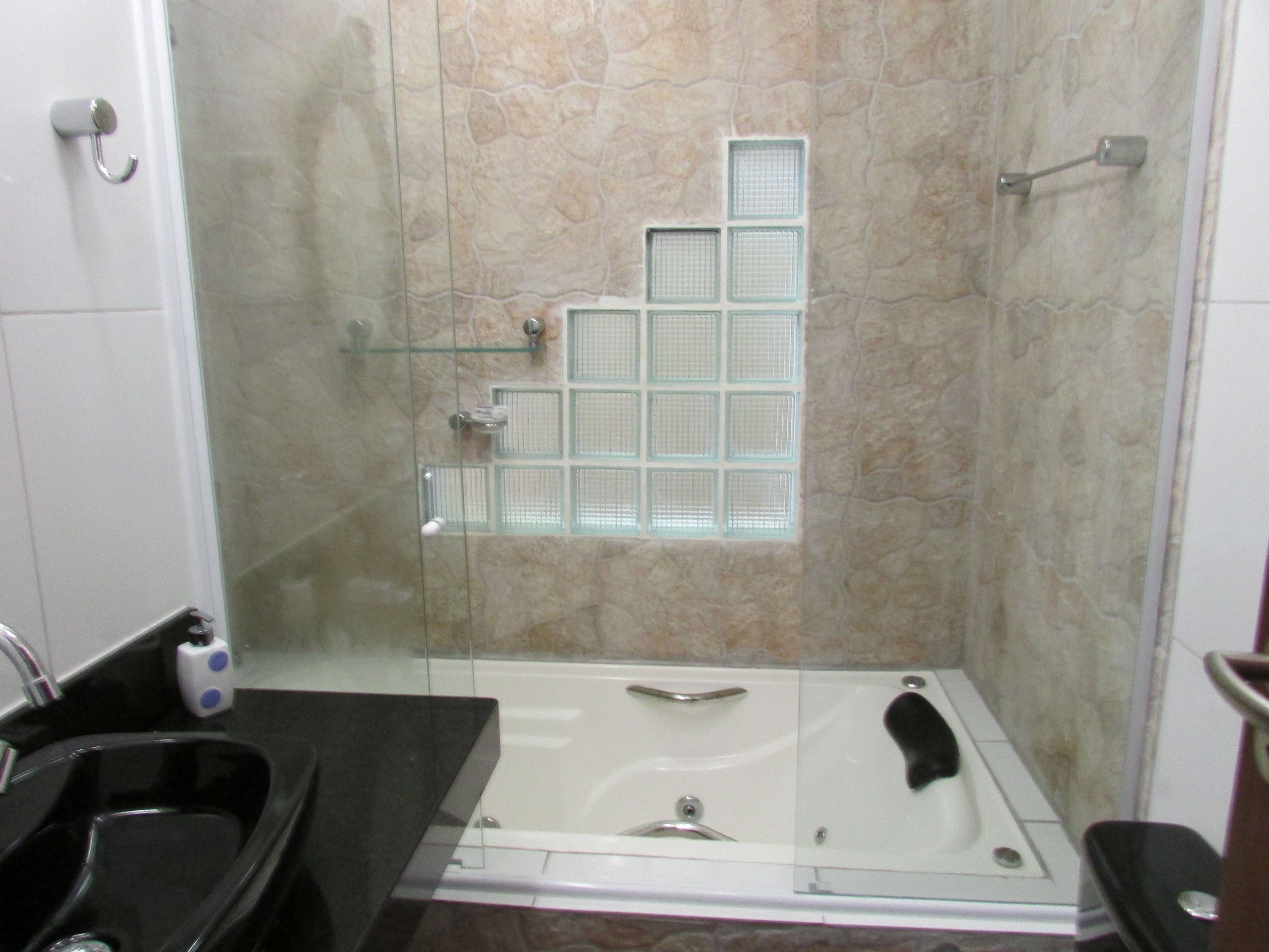 Un baño con ducha de vidrio, una bañera y un lavamanos.