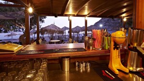 A bar area with a view of a beach and mountains, bar tools, and glasses on the counter. - Agia Fotia (Ierapetra)