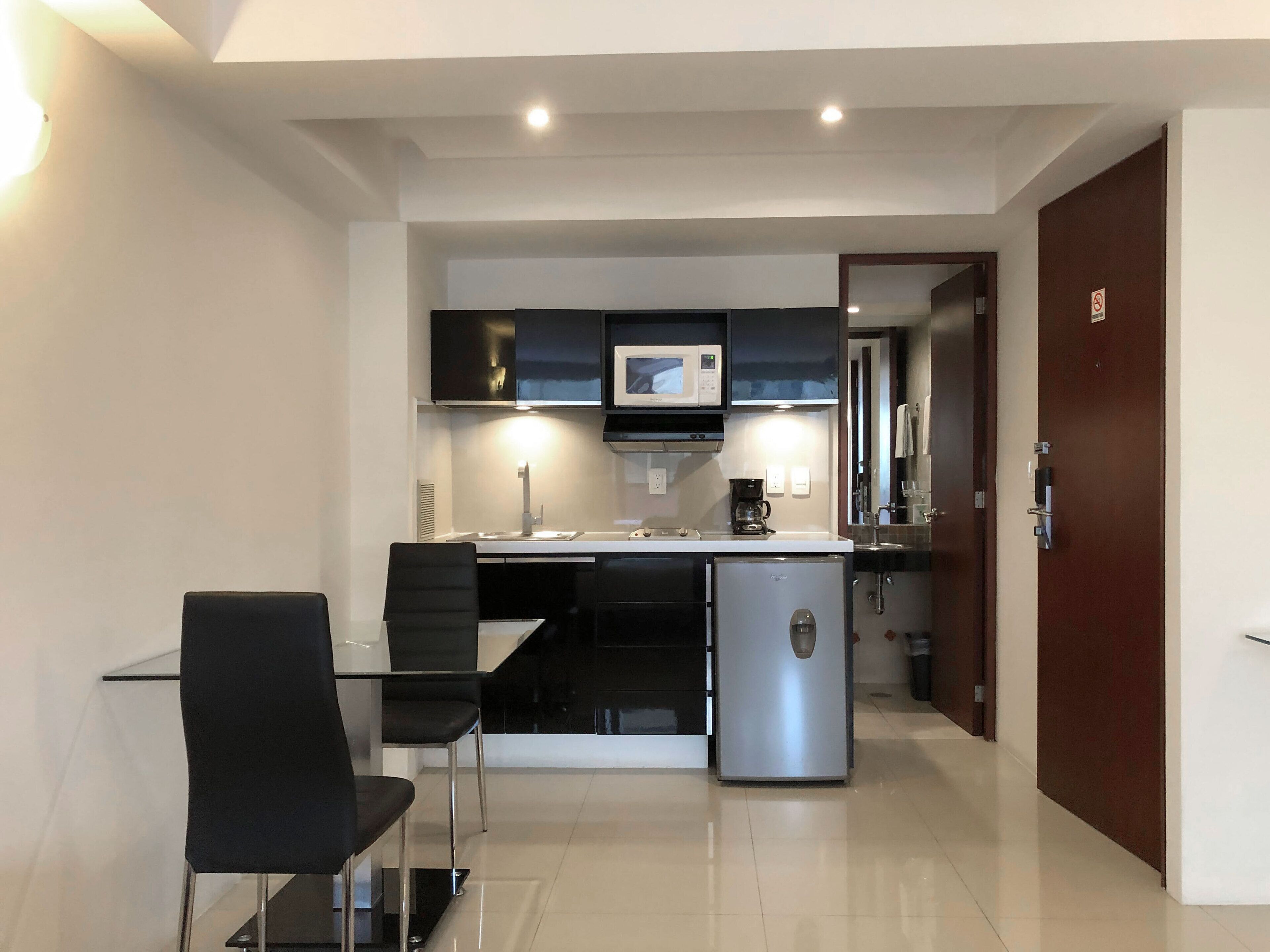 A modern kitchen with a dining area, a refrigerator, and a microwave.