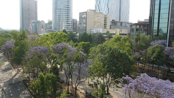 Un paisaje urbano con edificios modernos y una calle bordeada de árboles.
