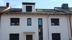 A two-story building with a flat roof, multiple windows, and a central entrance with a door. - Apartment Wesseling Zentrum (Wesseling)