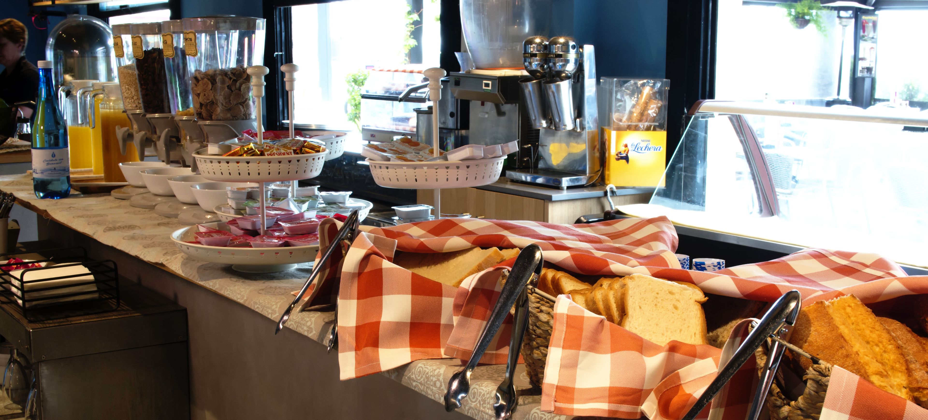 Un bufé de desayuno con diversas opciones de comida y una máquina de café.