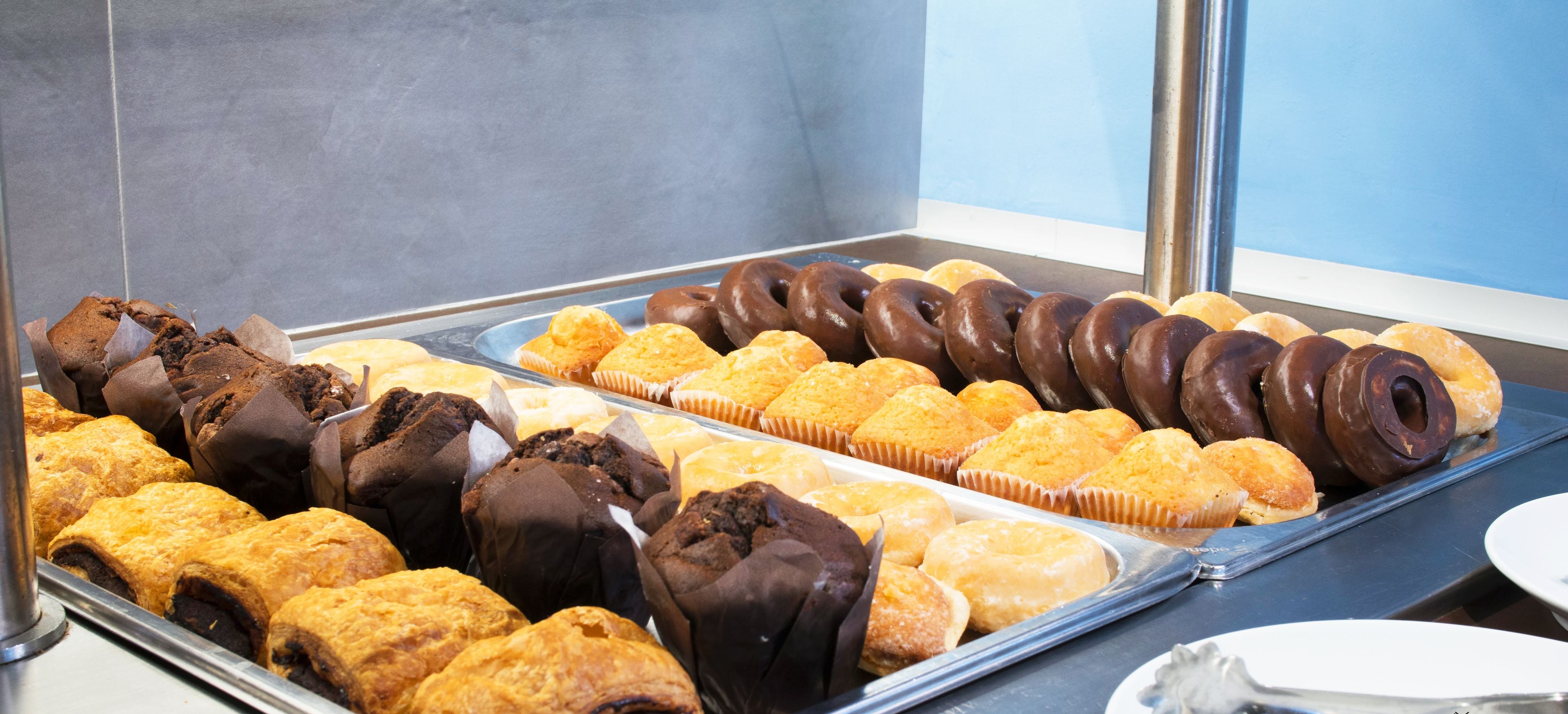 Eine Bäckertheke mit verschiedenen Gebäcken und Donuts.