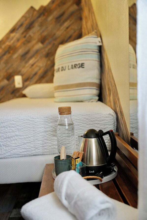 Una cama bien hecha con un almohadón que dice 'DU LARGE' en una habitación de hotel.