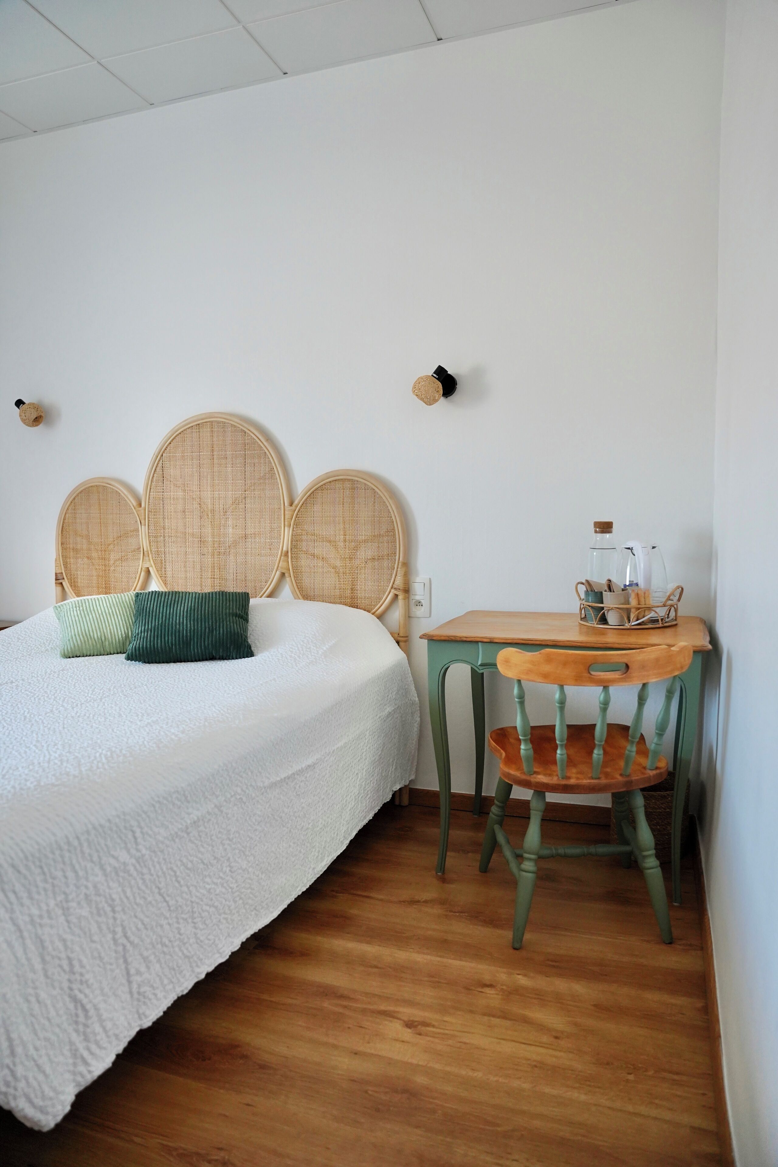 A room with a bed, a wooden table, and a chair.