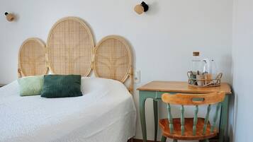 A room with a bed, a wooden table, and a chair.