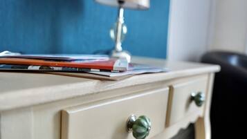 Un bureau avec une lampe, une chaise et un mur bleu en arrière-plan.
