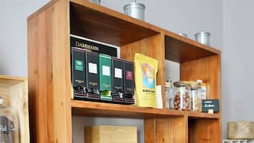A wooden shelf unit with various food items, glassware, and storage containers.