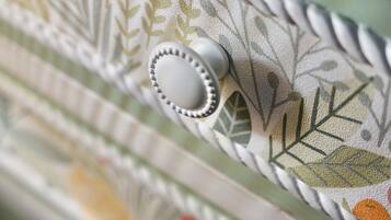 A close-up of a fabric with a leaf pattern and a button.