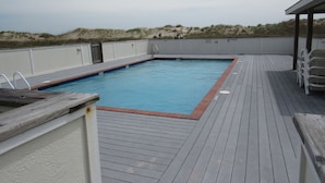 A rectangular swimming pool with a wooden deck surrounding it. - Sea Gull By Kees Vacations (Hatteras)