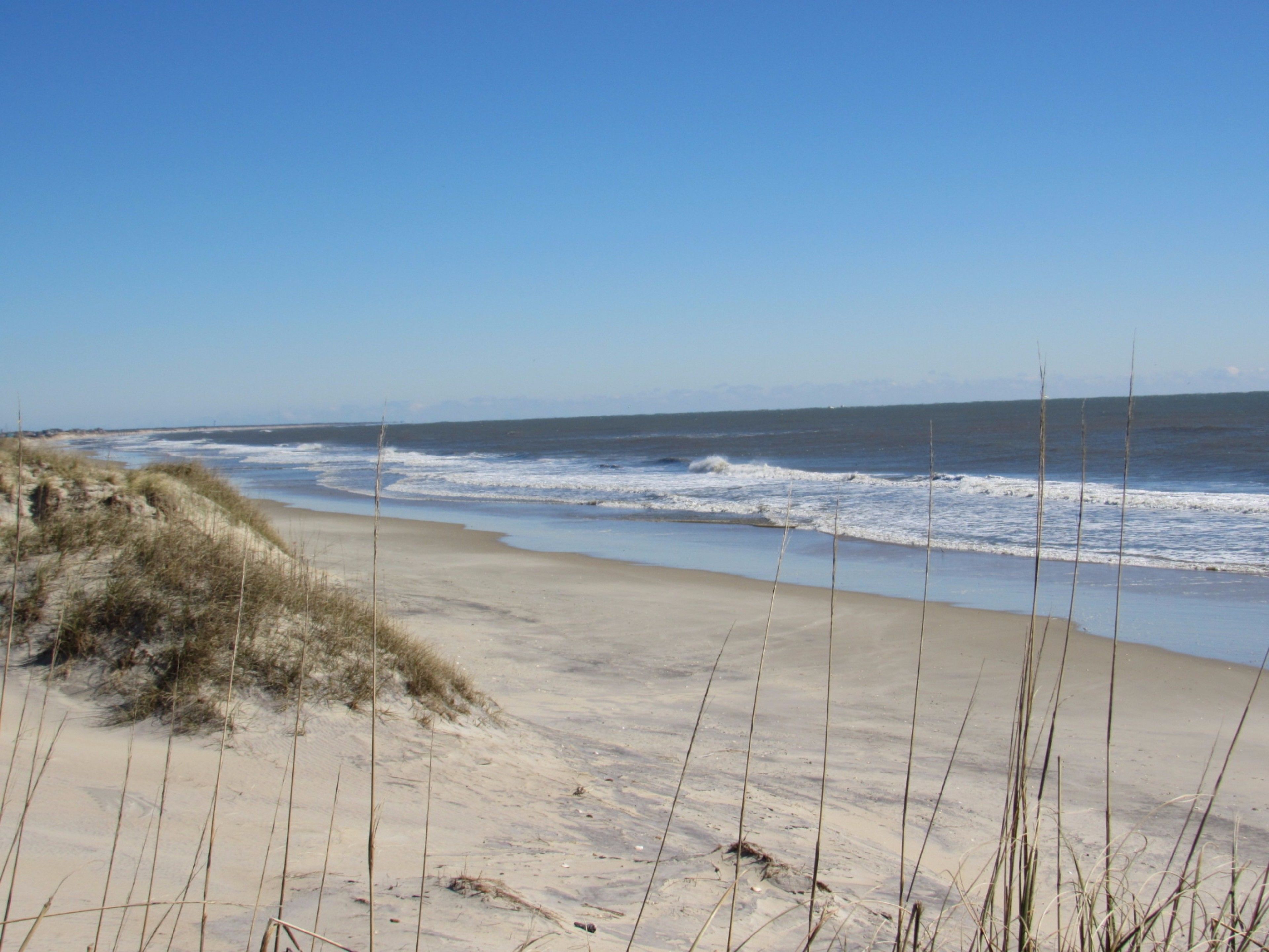 Une plage avec des dunes de sable et des vagues.