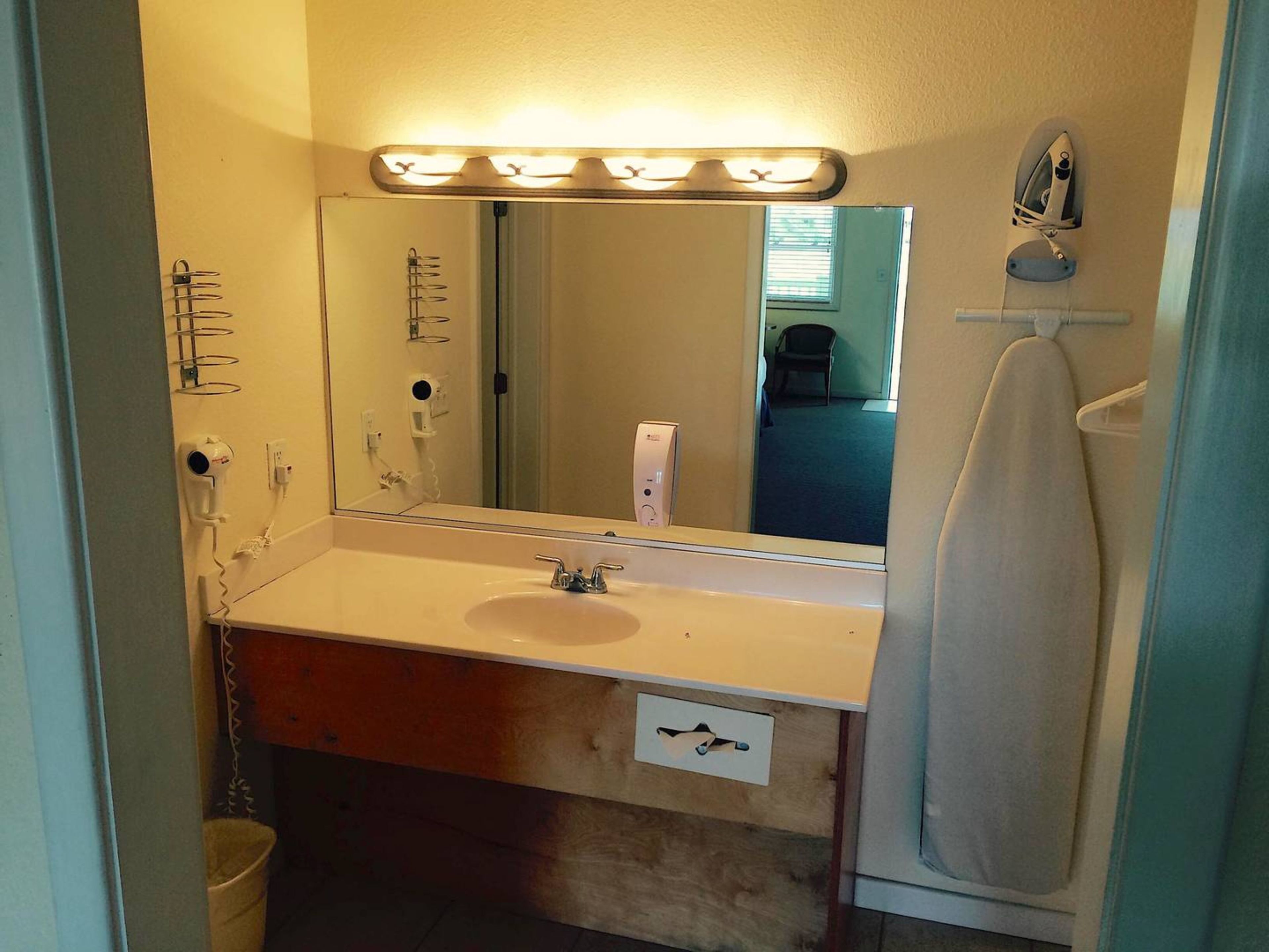 A bathroom with a sink, mirror, and towel rack.