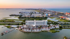 A coastal hotel with a marina, a large building with multiple floors, and a view of the city skyline in the background. - Residence Inn by Marriott Ocean City (Ocean City)