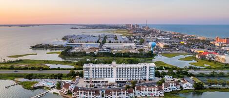 A coastal hotel with a marina, a large building with multiple floors, and a view of the city skyline in the background.