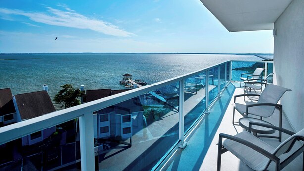 A balcony with a view of the sea, a pool, and a row of chairs. - Residence Inn by Marriott Ocean City (Ocean City)