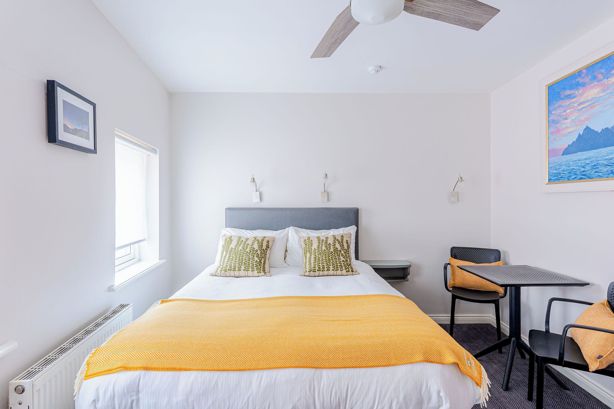 A bedroom with a bed, a desk, and a chair.