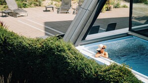 A poolside area with lounge chairs and a view of a swimming pool.