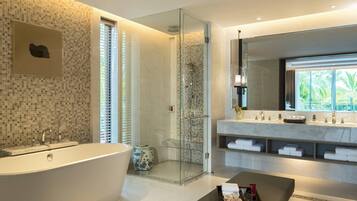 A modern bathroom with a freestanding bathtub, a glass-enclosed shower, and a large vanity with a mirror.