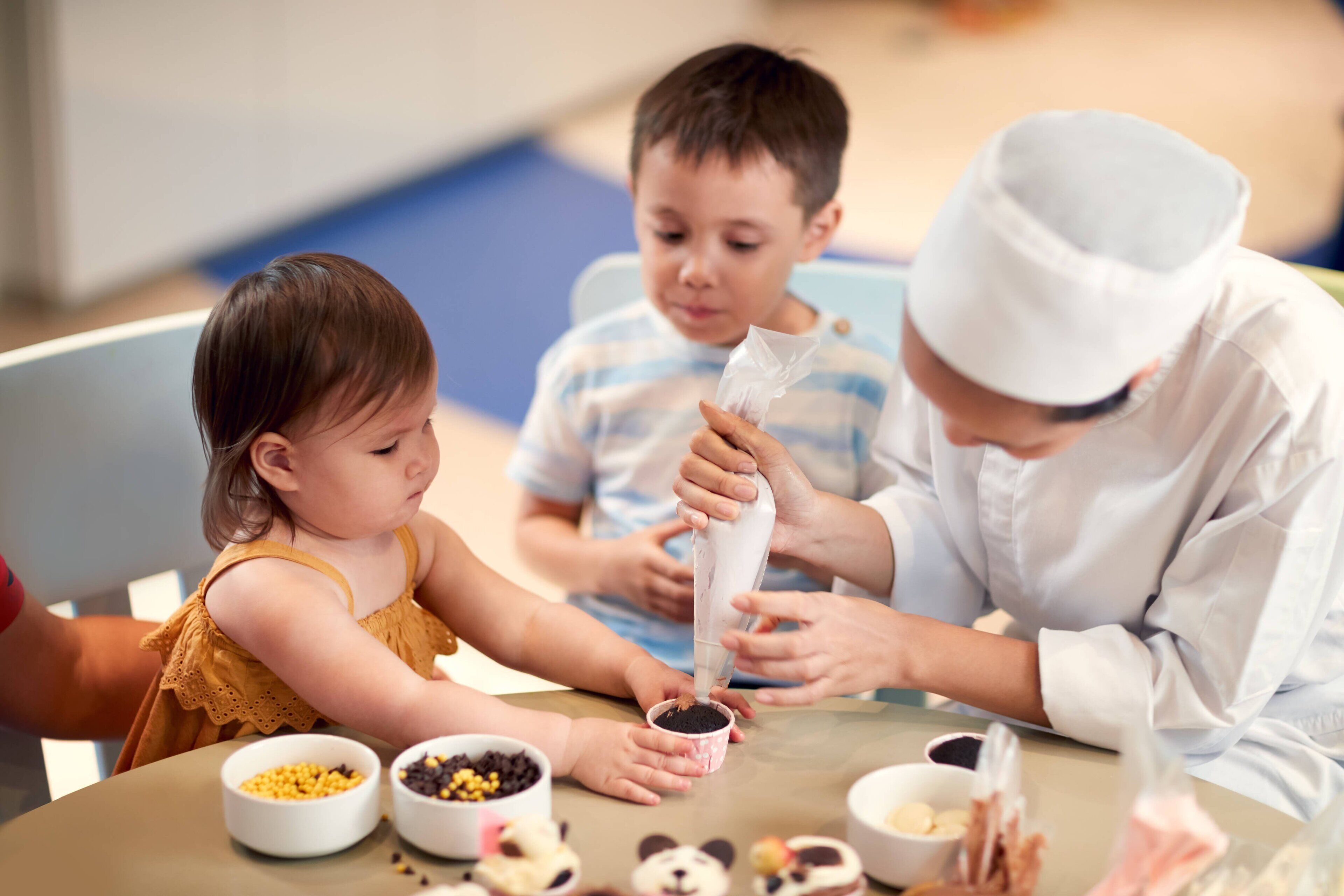 A group of people engaged in a food preparation activity with bowls of ingredients on a table.