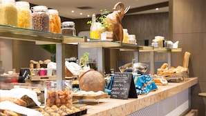 Un buffet de petit-déjeuner proposant une variété d’aliments et un menu écrit à la craie.