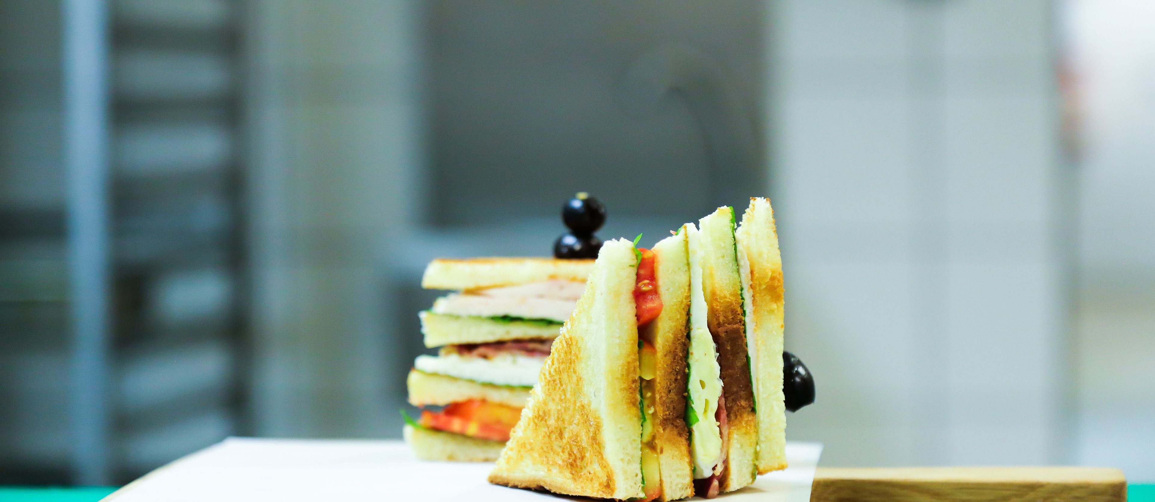 Un sándwich sobre un plato blanco, con un fondo desenfocado.