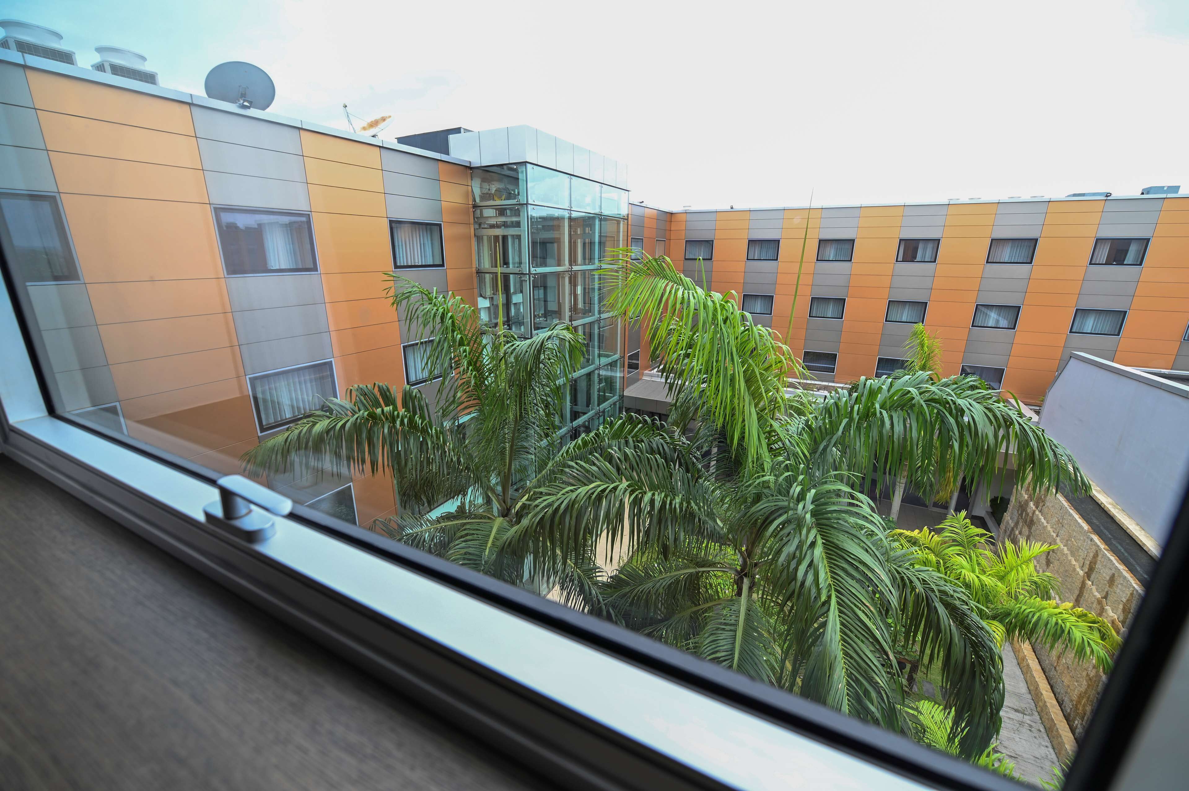 A modern building with a glass facade and orange and gray exterior.