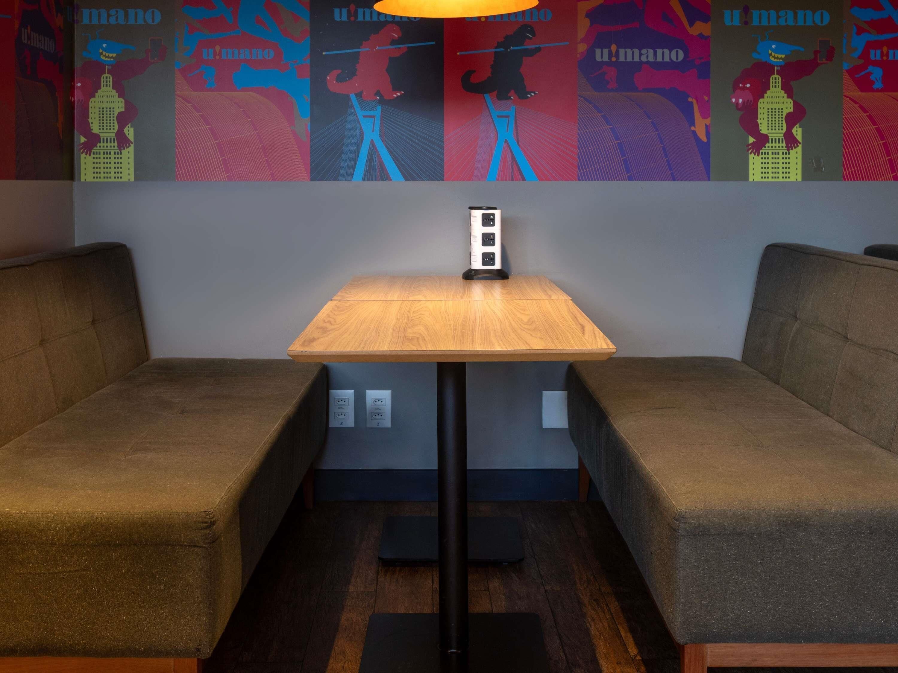 A small seating area with a wooden table and two cushioned benches.