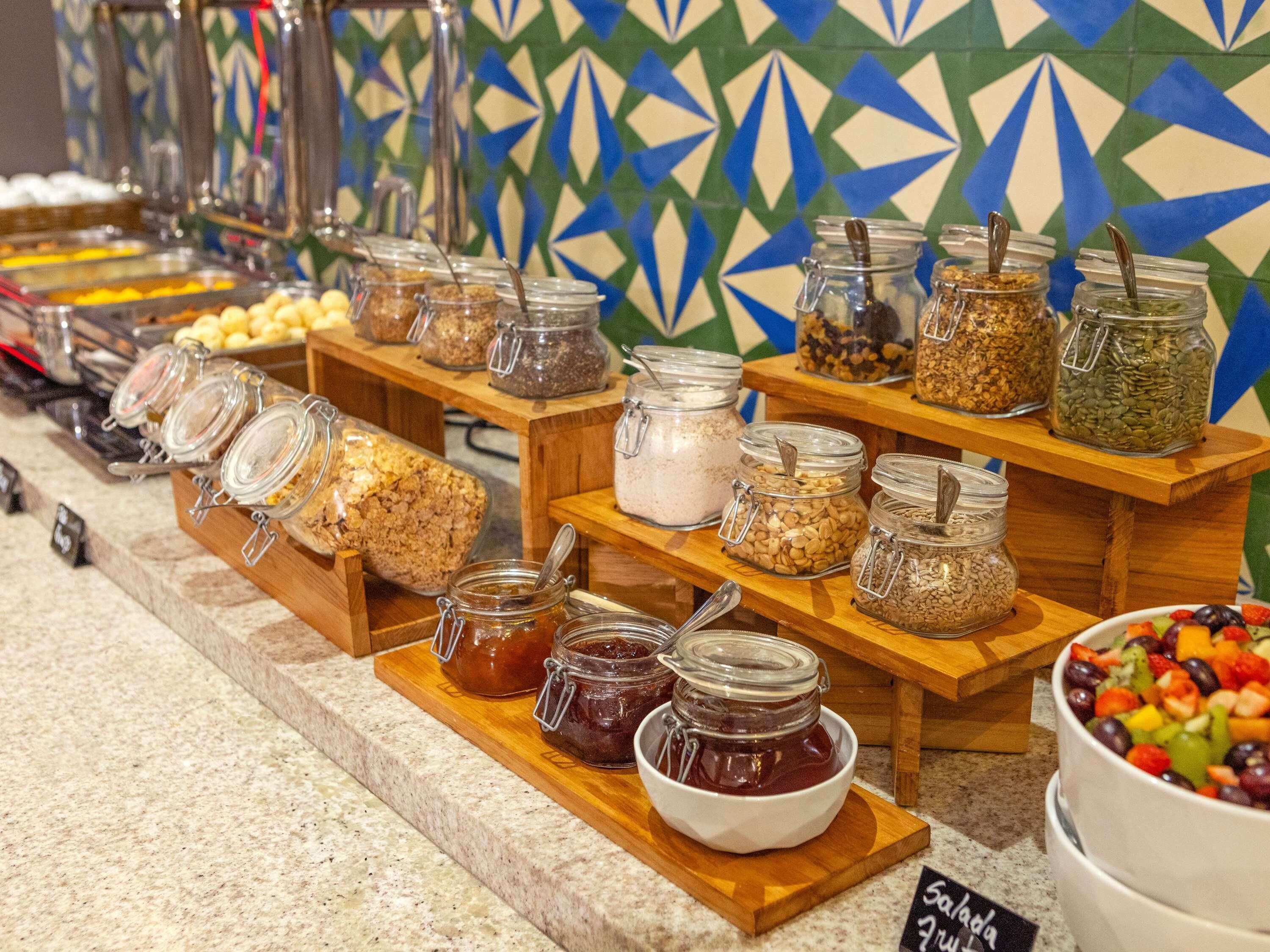 Um buffet com diversos alimentos em potes e tigelas, dispostos em suportes de madeira.