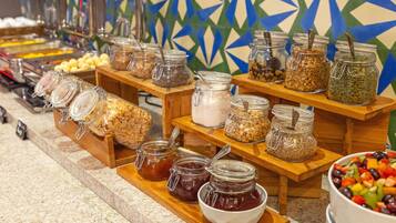 Um buffet com diversos alimentos em potes e tigelas, dispostos em suportes de madeira.