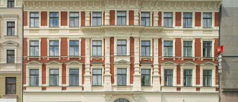 A multi-story hotel with a classic facade, large windows, and a prominent 'ibis HOTEL' sign.