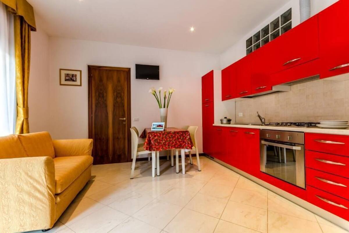 A compact living space with a kitchenette, a dining area with a table and chairs, and a sofa.