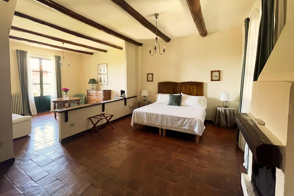 A bedroom with a wooden bed, a nightstand, a dresser, a chair, and a window with curtains.