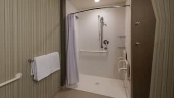 A walk-in shower with a grab bar, a towel rack, and a shower curtain.