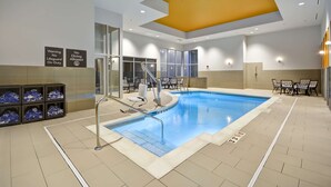 Ein modernes Hallenbad mit klarer Beschilderung, gefliestem Boden und gelber Decke.