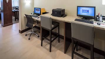 A workspace with two desks, computers, and office chairs.