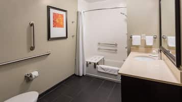 Un baño con inodoro, lavamanos, ducha y un cuadro en la pared.