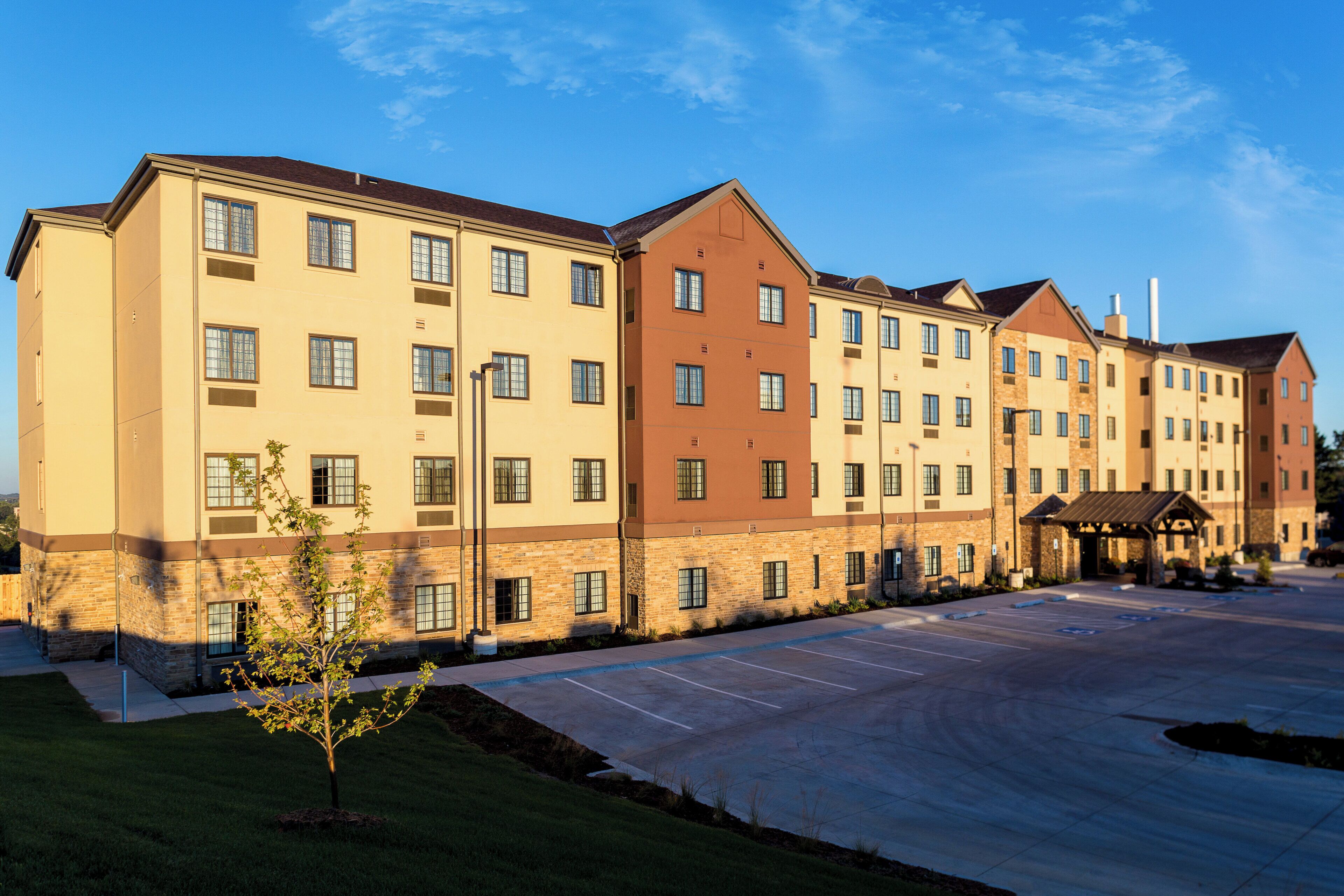 A multi-story hotel with a parking lot in front.