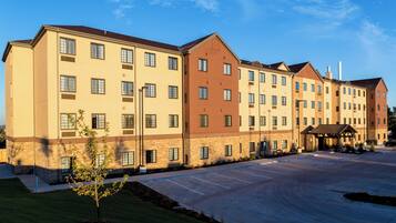 A multi-story hotel with a parking lot in front.