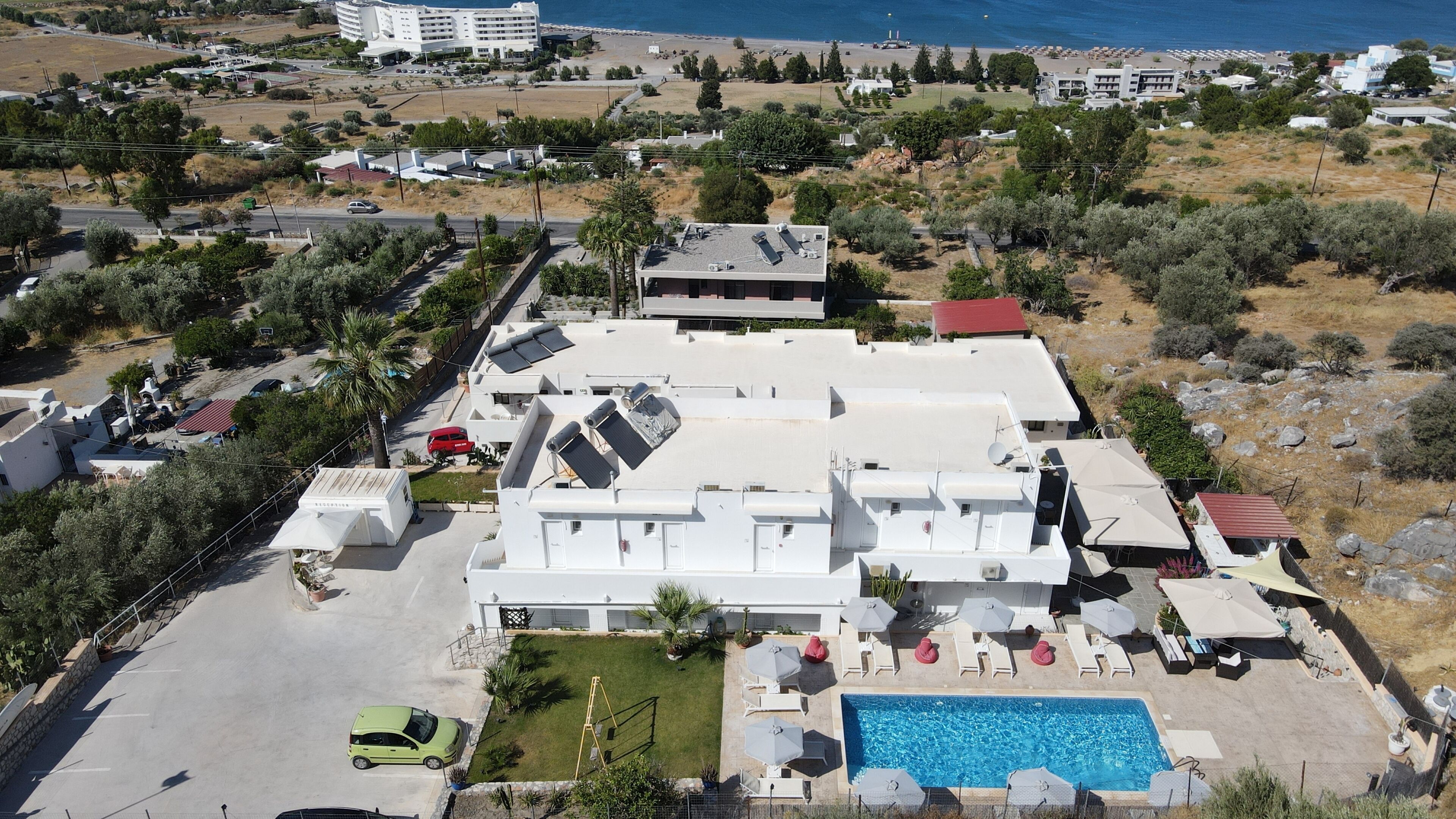 A residential building with multiple balconies, a swimming pool, and a view of the sea.