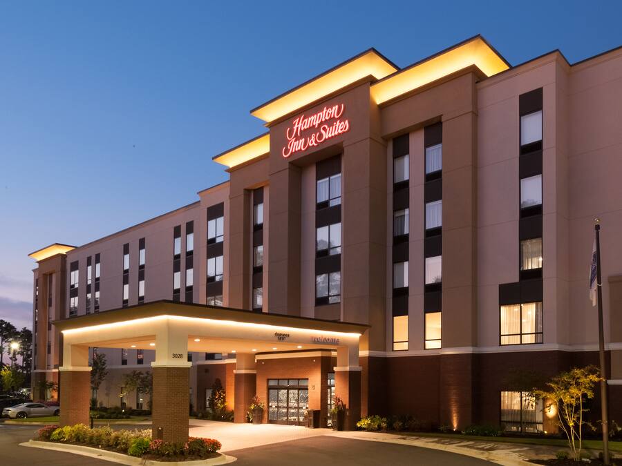 Un hotel Hampton Inn & Suites con una fachada moderna, ventanas amplias y una entrada acogedora.