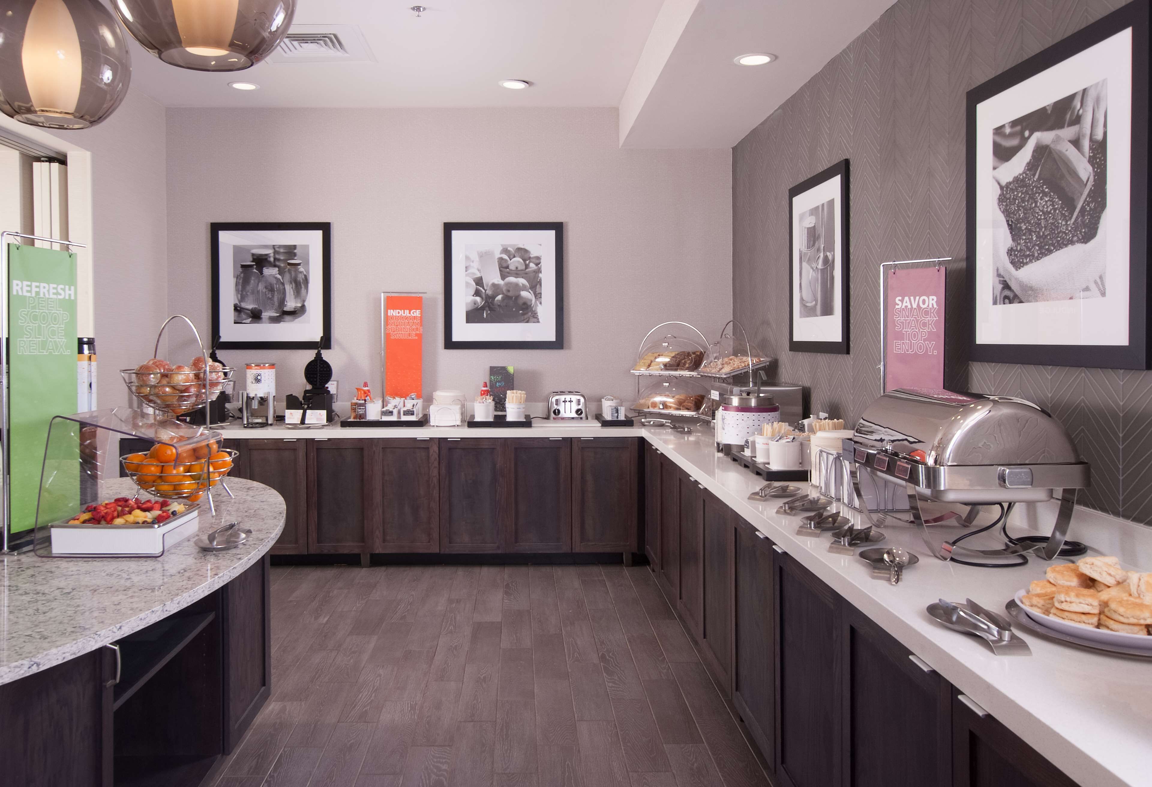 A modern kitchen with a marble countertop, equipped with a coffee machine, toaster, and various food items.