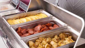 A buffet with labeled containers of boiled eggs, sausage, and potatoes.