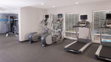 A fitness center with treadmills, elliptical machines, and a weight machine.