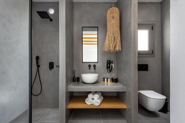 Un baño moderno con ducha, inodoro y lavamanos.